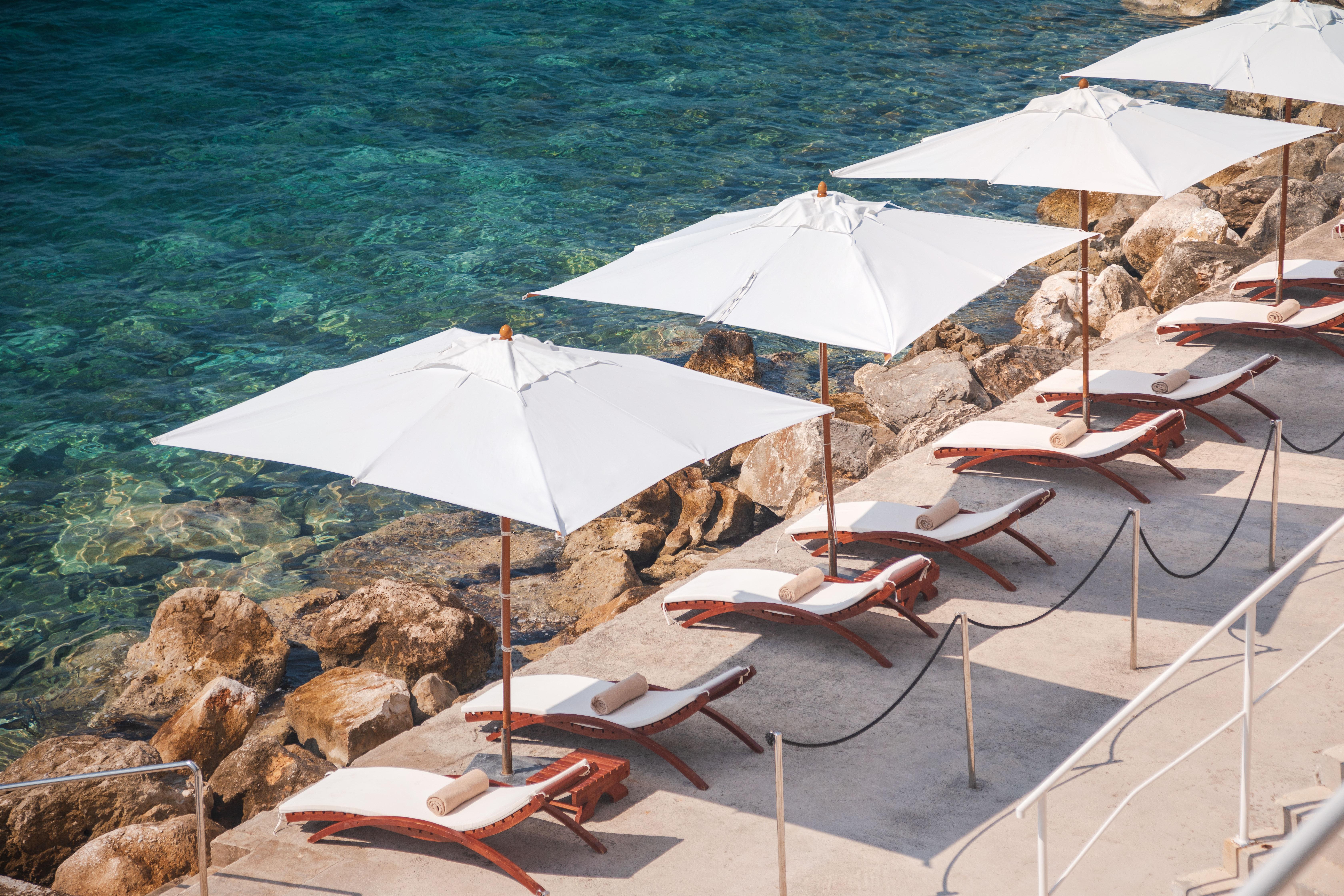 ホテル サン ガーデンズ ドゥブロブニク オラサック エクステリア 写真 Beach chairs and umbrella